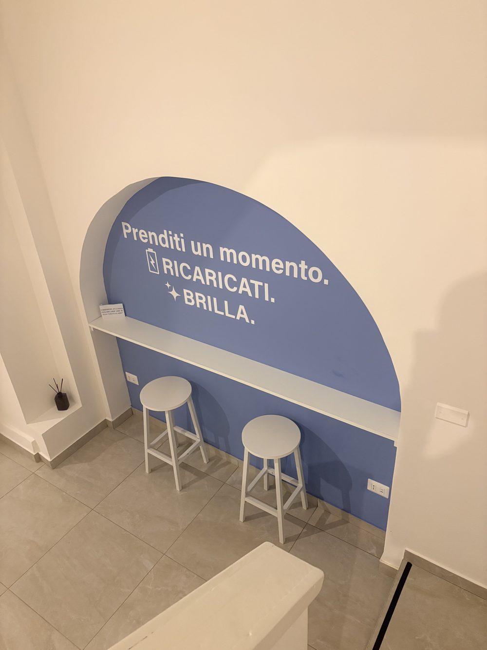 Angolo ricarica cellulare con sgabelli bianchi